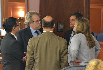 Rep David Guttenberg and members of the Alaska Independent and Democratic Caucus talk on the House Floor during an at ease