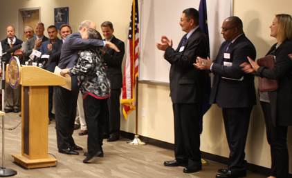 Above, Commissioner Davidson and Governor Walker hug after announcing the state will expand Medicaid.