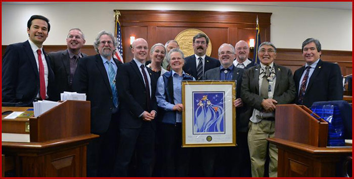 Sam stands with members of the House Bush Caucus during the last day of session as they present Rep. Austerman with a parting gift. 