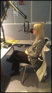 Erin cradling her baby bump during an emotional interview at KTOO.