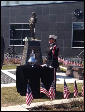 A representative of the U.S. Coast Guard poised to ring the bell for each departed service member.