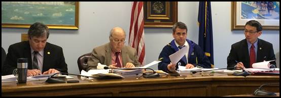 Rep. Tuck (second from right) leads members of his caucus in reviewing stacks of legislation in the waning days of session.